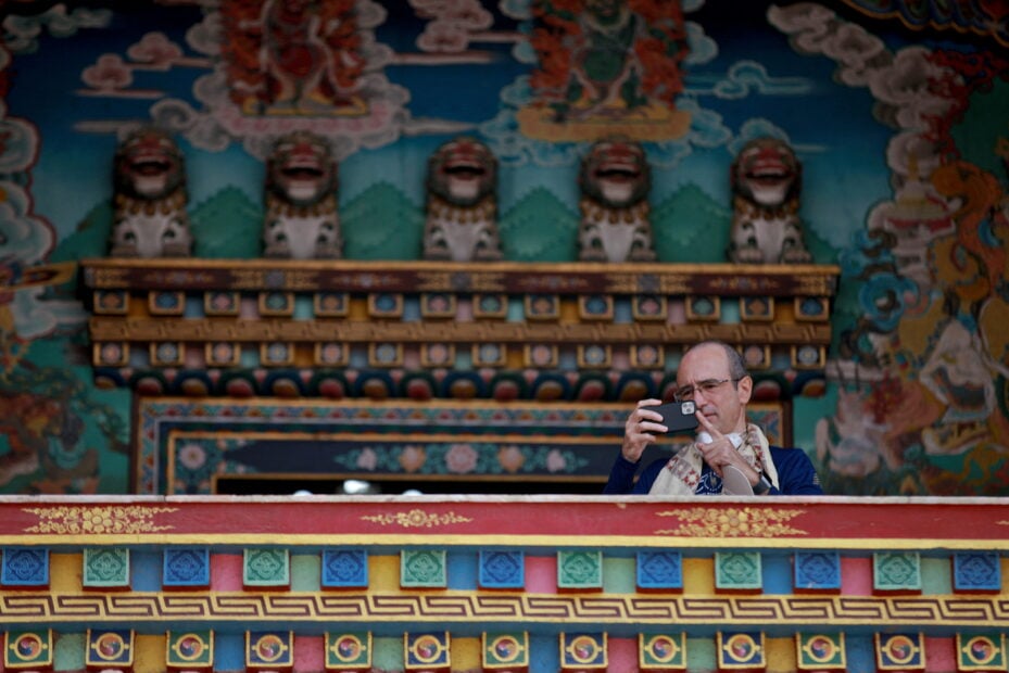 A foreign tourist take photographs of Boudhanath Stupa at a monastery in Kathmandu
