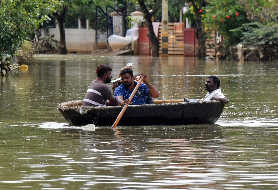 People use Coracle boat to move through a water-logged neighbourhood following torrential rains in Bengaluru